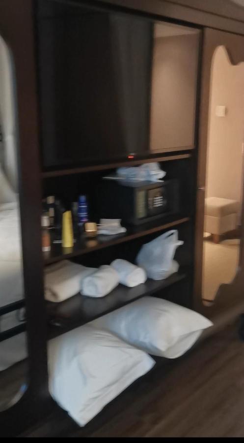 Buona Vitta Gramado Resort & Spa By Gramado Parks Bagian luar foto The photo shows a piece of furniture, likely a shelving unit or cabinet, with several items on it. There is a television mounted on top. Below the TV, there is a microwave and a small safe. The shelves contain various toiletries and personal care pro