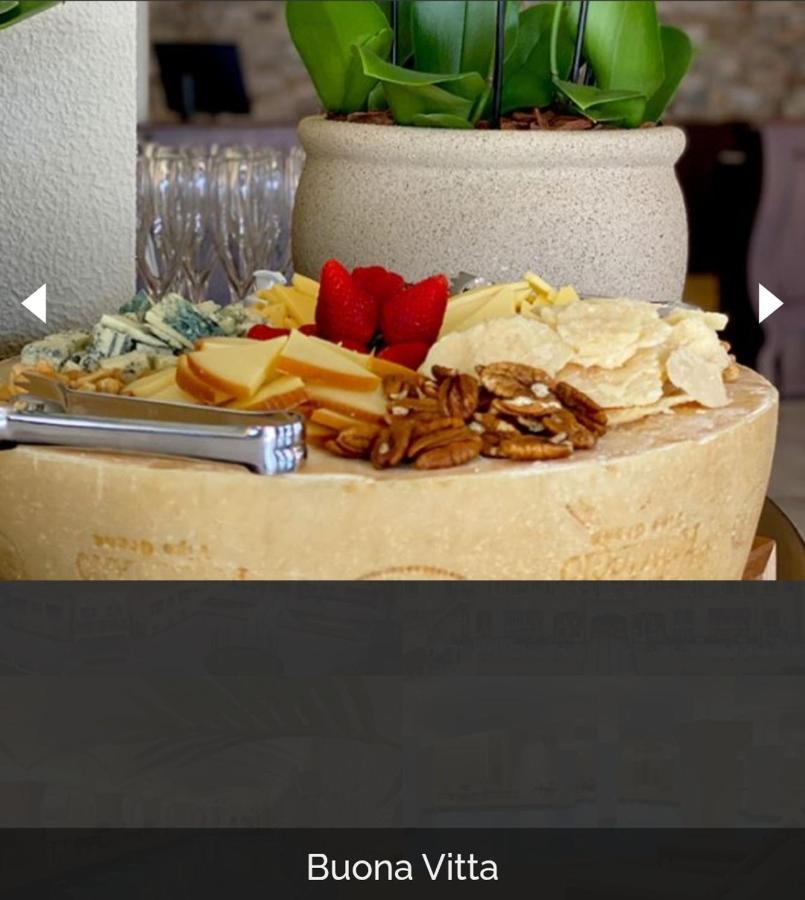 Buona Vitta Gramado Resort & Spa By Gramado Parks Bagian luar foto The photo displays a beautiful cheese platter. It features a large round cheese wheel as the base, surrounded by various types of cheeses including soft and hard varieties. There are also some crackers or crisps, along with nuts, particularly pecans.
