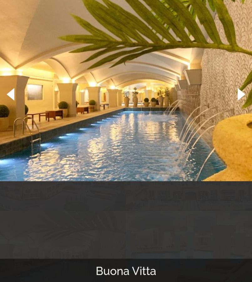 Buona Vitta Gramado Resort & Spa By Gramado Parks Bagian luar foto The photo depicts an elegant indoor swimming pool area. The pool is illuminated with lights along its edge, and there are gentle water features creating a calming atmosphere. The ceiling has an arched design, and the space is decorated with plants an
