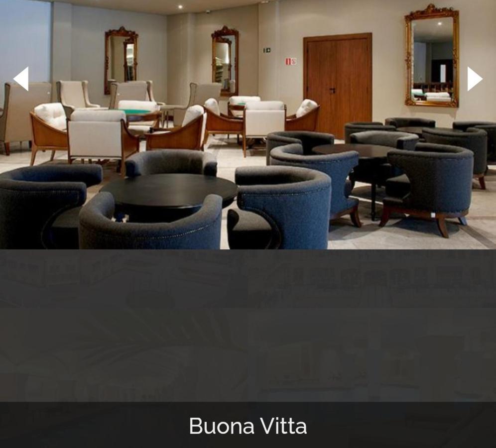 Buona Vitta Gramado Resort & Spa By Gramado Parks Bagian luar foto The photo shows a modern, elegantly designed lounge or waiting area. It features several circular seating arrangements with dark blue armchairs surrounding black tables. In the background, there are light-colored lounge chairs and a wooden door leadi