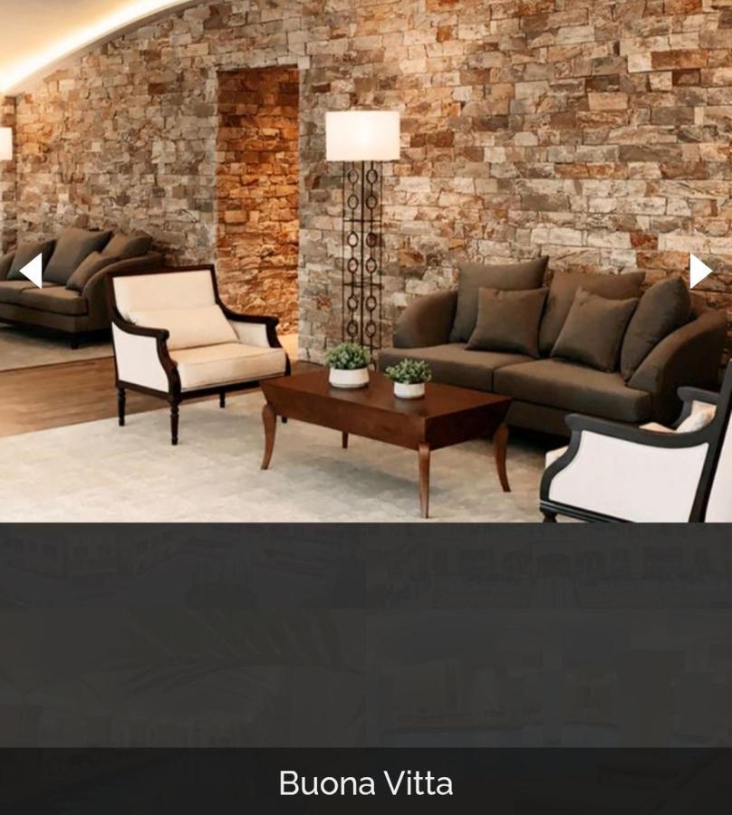 Buona Vitta Gramado Resort & Spa By Gramado Parks Bagian luar foto The image shows a stylish living room setting. There are two sofas: one is a dark brown color, and the other is a cream color with dark wooden accents. In the center, there is a wooden coffee table with a smooth finish and decorative plants on top. T