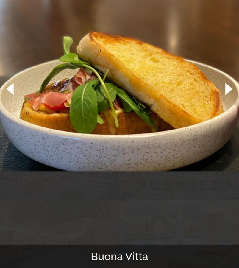 Buona Vitta Gramado Resort & Spa By Gramado Parks Bagian luar foto The photo shows a dish presented in a round, speckled bowl. It features a slice of toasted bread resting on top of a combination of ingredients beneath. The ingredients include leafy greens and slices of what appears to be cured meat, possibly ham. T