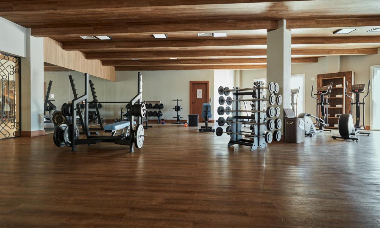 Buona Vitta Gramado Resort & Spa By Gramado Parks Bagian luar foto The photo shows a spacious gym with a wooden floor and wooden ceiling beams. Various pieces of gym equipment are visible, including weight benches and racks with weights. On one side, there are free weights organized on a rack, while other equipment 