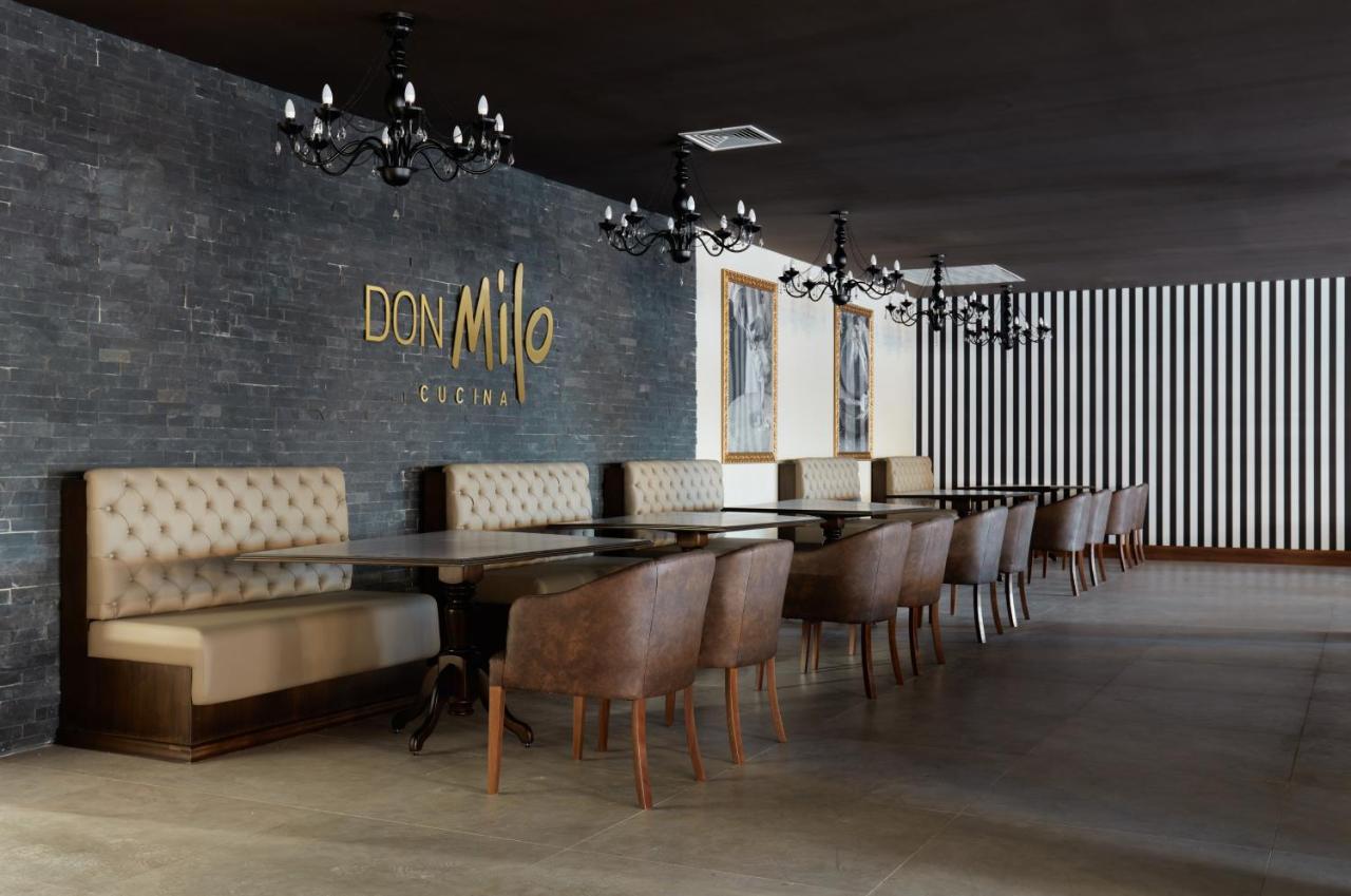 Buona Vitta Gramado Resort & Spa By Gramado Parks Bagian luar foto The photo showcases an interior of a restaurant named "Don Milo." The design features a modern and sophisticated look with a mix of textures and colors. 

On one side, there are upholstered booths in a neutral tone, creating a comfortable dining area