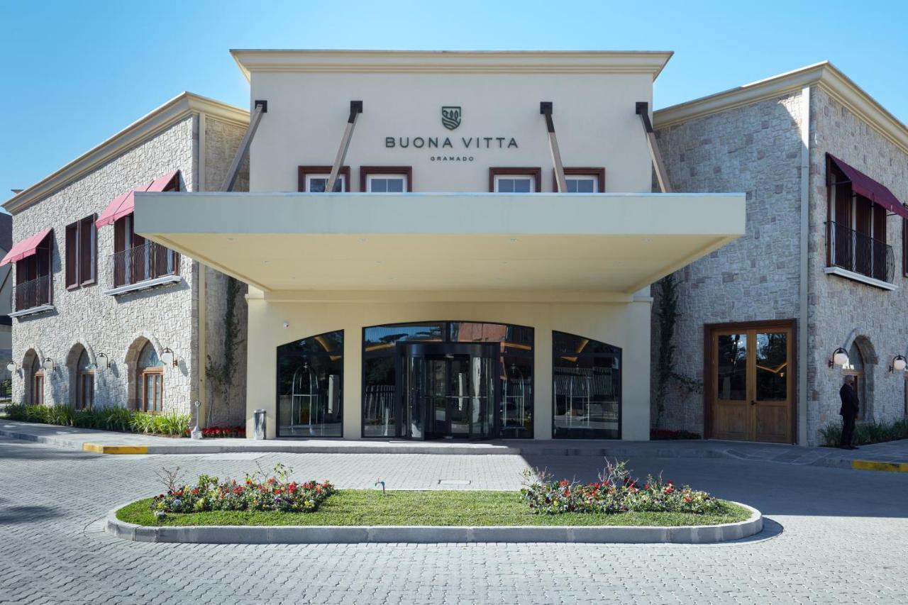 Buona Vitta Gramado Resort & Spa By Gramado Parks Bagian luar foto The photo shows a modern building with a prominent entrance marked by a large awning. The facade features a mix of stone and stucco materials, giving it an elegant and contemporary look. The name "BUONA VITTA" is displayed prominently above the entra