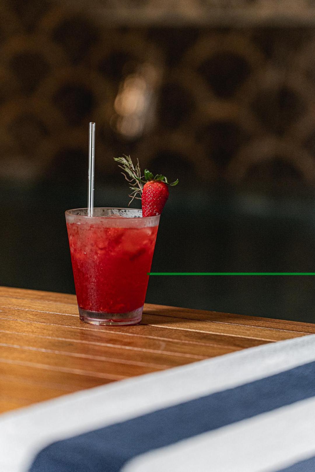 Buona Vitta Gramado Resort & Spa By Gramado Parks Bagian luar foto The photo shows a refreshing cocktail served in a transparent glass. The drink is vibrant red, suggesting it may be made with strawberries or a similar fruit. It features a straw and a garnish of a fresh strawberry on the rim of the glass, along with