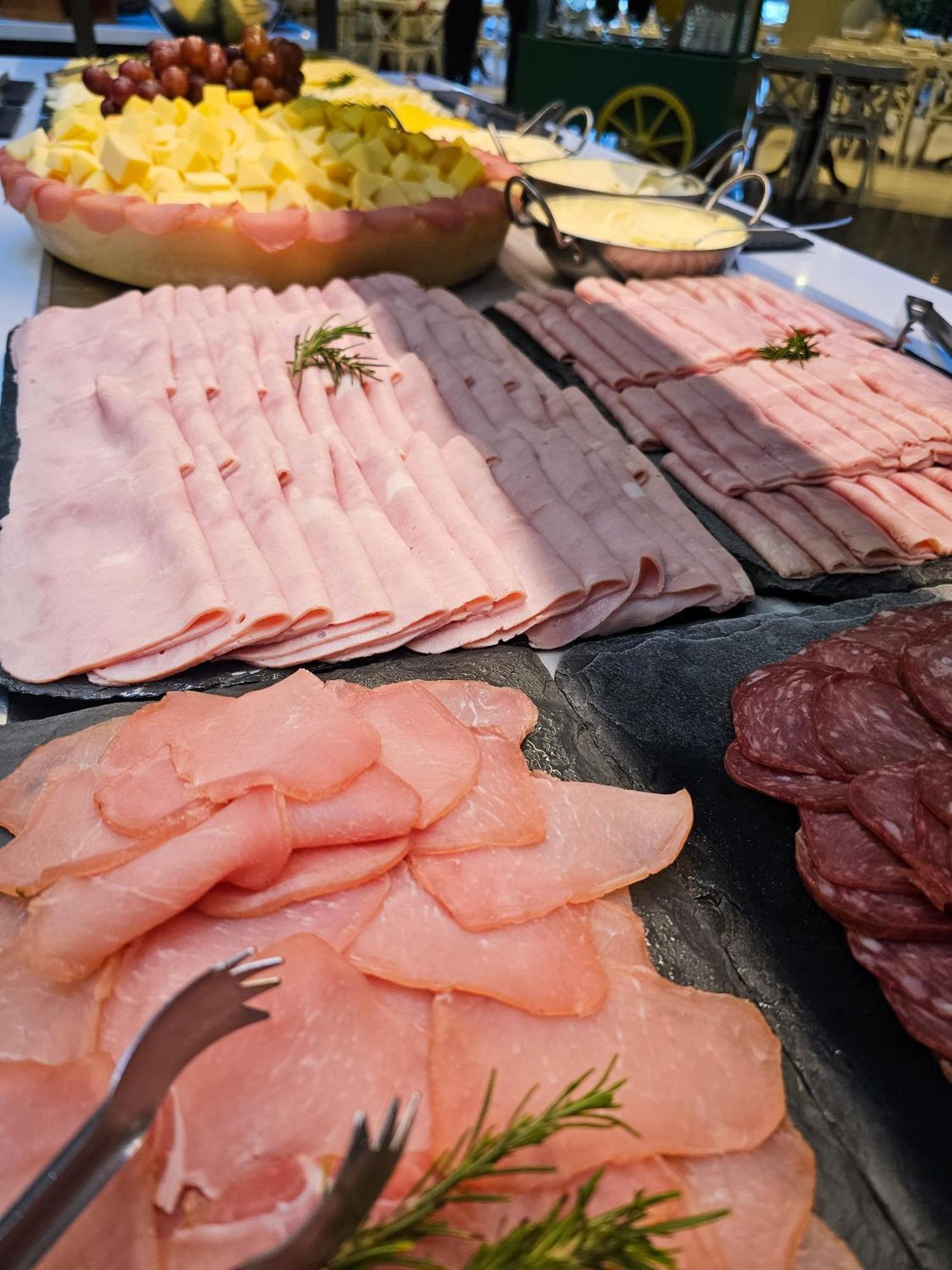 Buona Vitta Gramado Resort & Spa By Gramado Parks Bagian luar foto The photo shows a display of various types of sliced deli meats arranged on a flat surface. There are several layers of thinly sliced, pale-colored meats, likely including ham or turkey, organized neatly in parallel rows. Additionally, there are slic